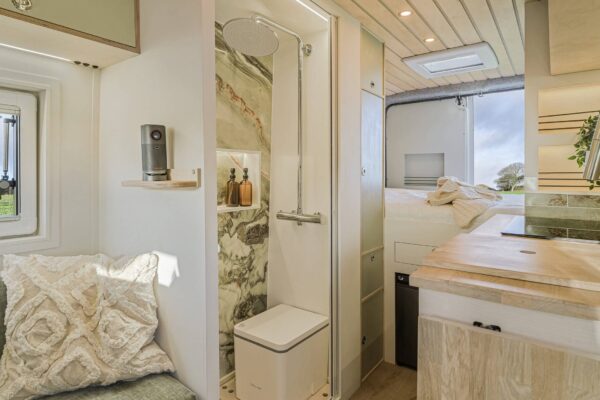 Campervan interior detail with patterned cushions and soft furnishings in muted colours.