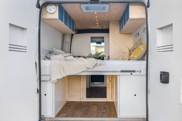 Campervan kitchen sink and tap detail with warm lighting and minimalist finish.