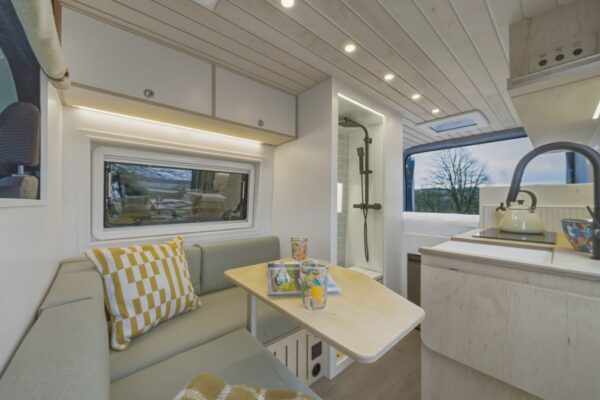 Bright campervan kitchen and lounge layout inside a Bhode conversion with skylight above