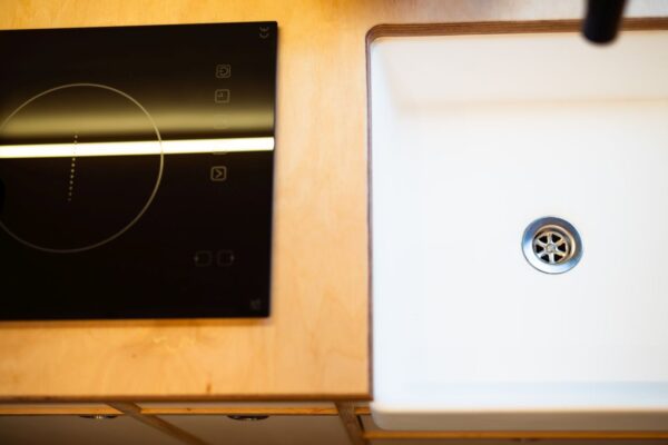 Induction hob installed in a Bhode campervan kitchen with minimalist worktop design