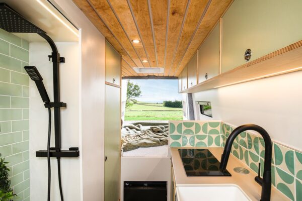 Fixed rear bed and shower room inside a handcrafted campervan conversion