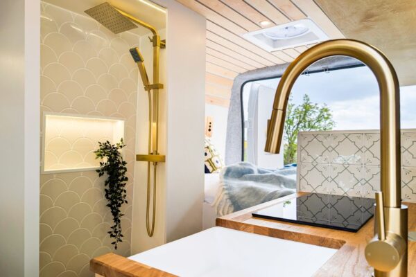 Luxury campervan shower room with brass fittings and tiled feature wall