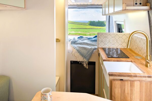 Bespoke campervan interior with fixed rear bed, shower room and oak kitchen