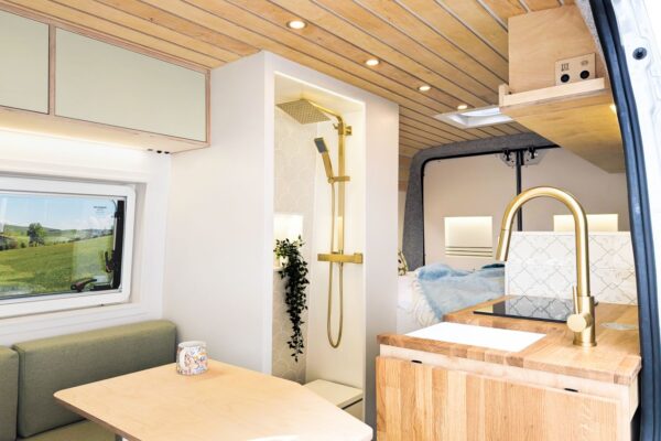 Luxury campervan interior featuring lounge seating, shower room and oak kitchen