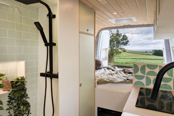 Modern campervan shower room with black shower fittings and tiled wall