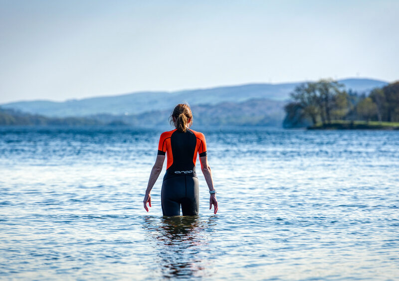 Woman wild swimming in a calm mountain lake